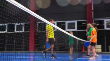 İki yetişkin ve iki çocuk, mavi, iç sahada oynadıktan sonra beşlik çakıyor.