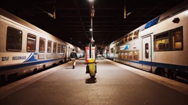 Cannes, Fransa - 4 Aralık 2024: İnsanlar ve trenler akşam saatlerinde Cannes tren istasyonunda hareket ediyor