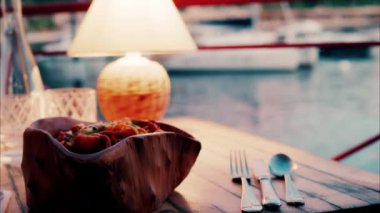 Fransa 'nın güneyindeki bir limanın yakınındaki bir restoranın sehpasında bir lambanın yakın görüntüsü.