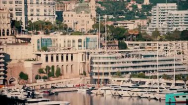 Monaco Marina 'ya kenetlenmiş teknelerin görüntüsü ve arka planda şehrin silüeti.