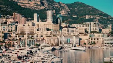 Monaco Marina 'ya kenetlenmiş teknelerin görüntüsü ve arka planda şehrin silüeti.