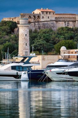 Antibes kalesi ve limanı mavi gökyüzü üzerinde tekneleri ve kulesi olan