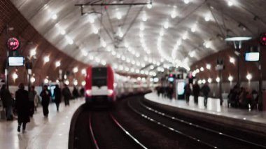 Monako, Monako 'daki Monako tren istasyonunda parlak ışıklarla hareket eden insanların ve trenlerin bulanık görüntüsü