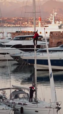 La Condamine, Monako - 10 Aralık 2024 Monaco Marina 'da bir teknede çalışan iki adam