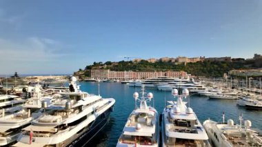 Monaco Marina 'ya kenetlenmiş beyaz tekne manzarası. Arka planda şehrin silüeti var.