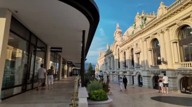 Monte Carlo, Monaco - 4 Ekim 2024: Şehirde bir caddede insanların dolaştığı lüks mağazalar