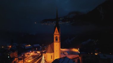 San Lorenzo Kilisesi 'nin insansız hava aracı görüntüsü Dolomites, İtalya' daki Selva di Cadore komün 'ünde gece aydınlandı.