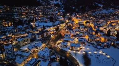 Ortisei kasabasının hava aracı görüntüsü gece karla kaplı, Dolomitler içinde, kuzey İtalya 'da.