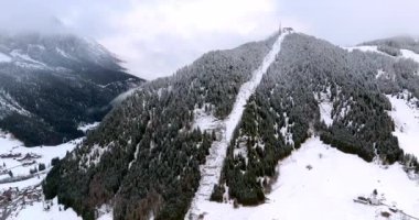 Kuzey İtalya 'daki Güney Tyrol, Dolomitler ve karla kaplı Corvara köyünün insansız hava aracı görüntüsü.