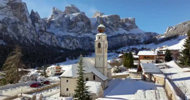 Colfosco dağ köyündeki Parrocchia di Colfosco 'nun hava aracı görüntüsü karla kaplı, Güney Tyrol, Dolomites, Kuzey İtalya