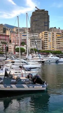 La Condamine, Monaco - 8 Eylül 2024: Monaco Marina 'da kentin ufuk çizgisi olan beyaz teknelerin görüntüsü. Dikey