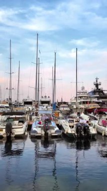 Monaco Marina 'ya kenetlenmiş beyaz tekne manzarası ve arka planda şehrin ufuk çizgisi. Dikey