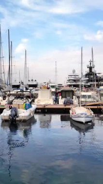 Monaco Marina 'ya kenetlenmiş beyaz tekne manzarası ve arka planda şehrin ufuk çizgisi. Dikey