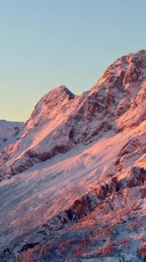 Gün batımında İtalya 'nın Dolomitler kentindeki dağlardaki karların insansız hava aracı görüntüsü. Dikey