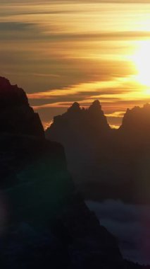 Gün batımında İtalya 'nın Dolomitler kentindeki dağlardaki karların insansız hava aracı görüntüsü. Dikey