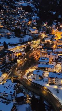 Ortisei kasabasının hava aracı görüntüsü gece karla kaplı, Dolomitler içinde, kuzey İtalya 'da. Dikey