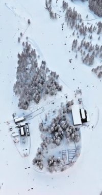 Güney Tyrol, Dolomites, Kuzey İtalya 'da karla kaplı Colfosco dağ köyünün insansız hava aracı görüntüsü. Dikey