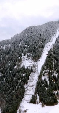 Kuzey İtalya 'daki Güney Tyrol, Dolomitler' de karla kaplı Corvara köyünün insansız hava aracı görüntüsü. Dikey