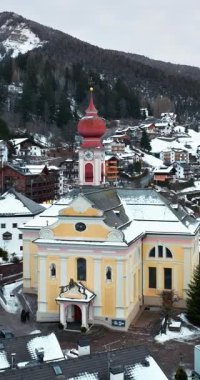 Kuzey İtalya 'daki Dolomitler' in içinde karla kaplı Ortisei kasabasının insansız hava aracı görüntüsü. Dikey