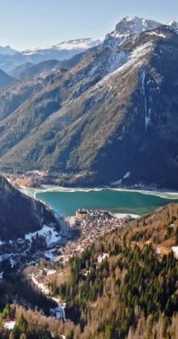 İtalya 'nın Dolomites eyaletinin Belluno ilindeki Alleghe Gölü ile Alleghe köyünün insansız hava aracı görüntüsü. Dikey