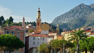 Menton, Fransa - 4 Eylül 2024: St. Michel Bazilikası 'nın renkli binalarla çevrili uzak manzarası