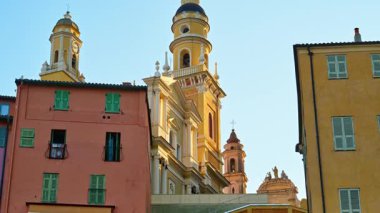 Menton, Fransa - 4 Eylül 2024: Renkli binalarla çevrili Aziz Michel Bazilikası manzarası