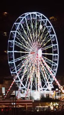 Monako 'daki Port Hercule Funfair' de gece vakti yanan dönme dolabı kapatın. Dikey