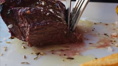 Kazığın yakınında patates kızartması ve salatayla beyaz bir tabakta kesilecek.