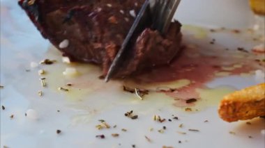 Kazığın yakınında patates kızartması ve salatayla beyaz bir tabakta kesilecek.