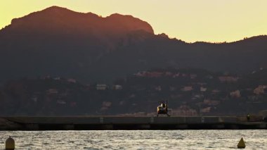 Gün batımında kalkmaya hazırlanan bir helikopterin görüntüsü. Güney Fransa 'da dağlar arka planda.