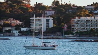 Juan-les-Pins, Fransa - 25 Ocak 2025: Gün batımında denizde yüzen küçük tekne