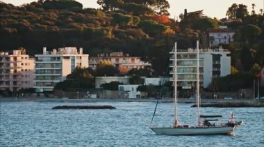 Juan-les-Pins, Fransa - 25 Ocak 2025: Gün batımında denizde yüzen küçük tekne