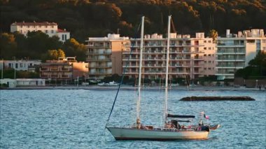 Juan-les-Pins, Fransa - 25 Ocak 2025: Gün batımında denizde yüzen küçük tekne