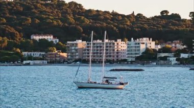 Juan-les-Pins, Fransa - 25 Ocak 2025: Gün batımında denizde yüzen küçük tekne