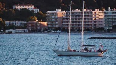Juan-les-Pins, Fransa - 25 Ocak 2025: Gün batımında denizde yüzen küçük tekne