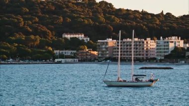 Juan-les-Pins, Fransa - 25 Ocak 2025: Gün batımında denizde yüzen küçük tekne