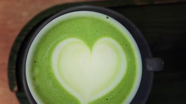 Bir kafede siyah tepside bir matcha latte yakın çekim