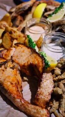 Fritto Misto tabağını somon ve patatesle kapatın. Dikey