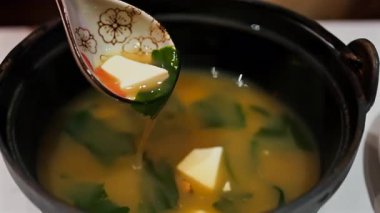 Lokantada miso çorbası hazırlayan bir kadının yakın çekimi.