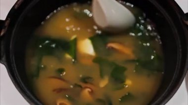 Lokantada miso çorbası hazırlayan bir kadının yakın çekimi.