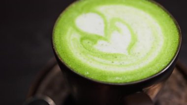 Bir kafede tepside bir kibrit sütlü kahve yakın.