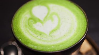 Bir kafede tepside bir kibrit sütlü kahve yakın.