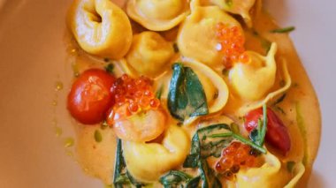Bir restoranda deniz ürünü ve soslu ravioli tabağını kapat.