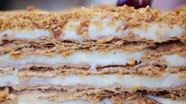 Kırmızı ve beyaz bir tabakta Medovik pastasından bir dilim yakın.