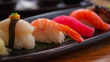 Lokantada siyah bir tepside birden fazla Nigiri 'ye yaklaş.