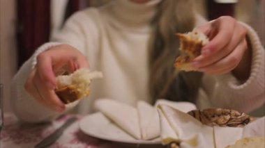 Ekmeği zeytinyağına batıran ve bir restoranda yiyen bir kadının yakınına.