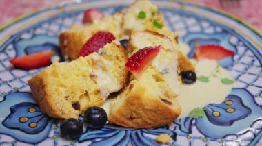 Üzerinde yoğunlaştırılmış süt ve böğürtlen olan panettone parçalarını kapat