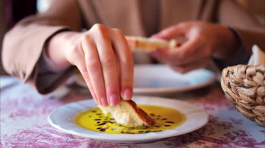 Ekmeği balzamik jöleli zeytinyağına batırıp bir restoranda yiyen bir kadına yaklaş.