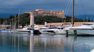 Antibes, Fransa - 20 Şubat 2025: Arka planda Fort Carre ile Vauban Limanı 'na yanaşan tekneler