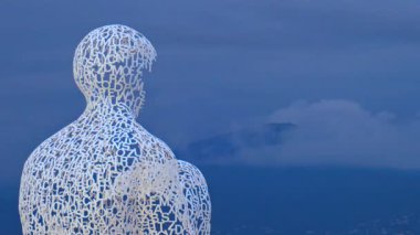 Fransa 'nın Antibes şehrinde akşam saatlerinde Jaume Plensa' nın Göçebe şehir heykelinin uzaktan görünüşü
